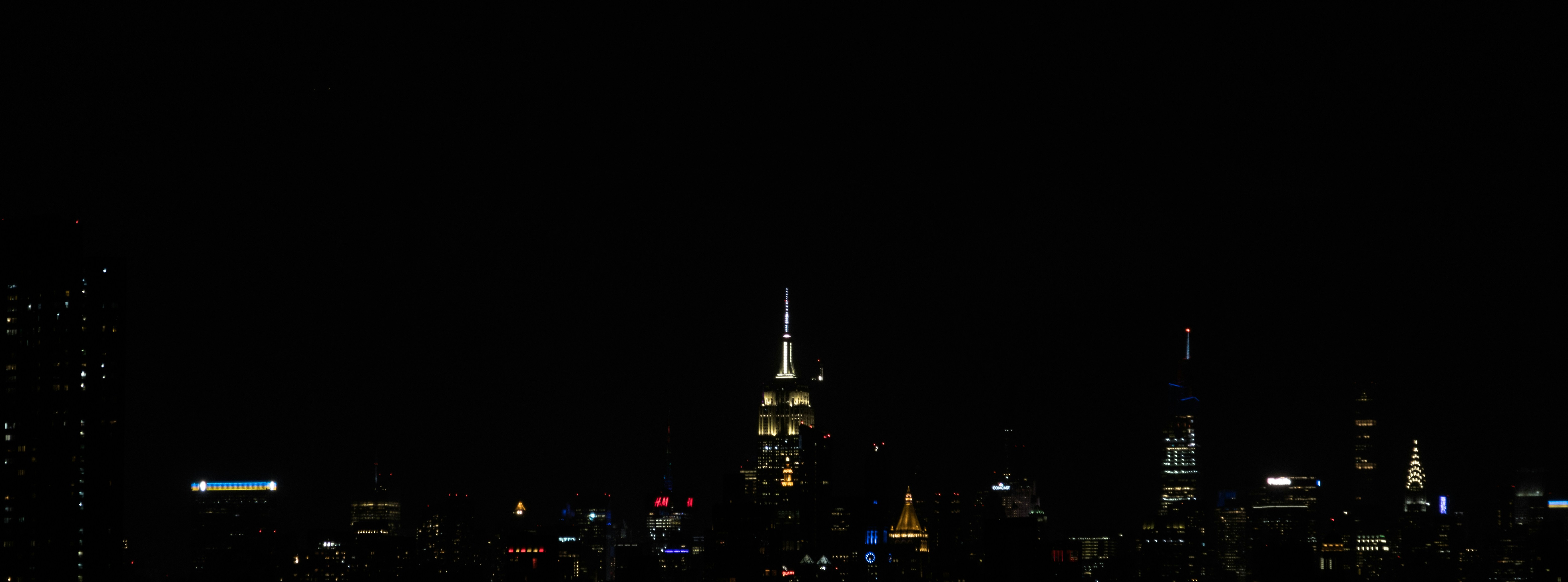 City skyline at night with digital light overlays and data visualization patterns, dark atmospheric urban environment