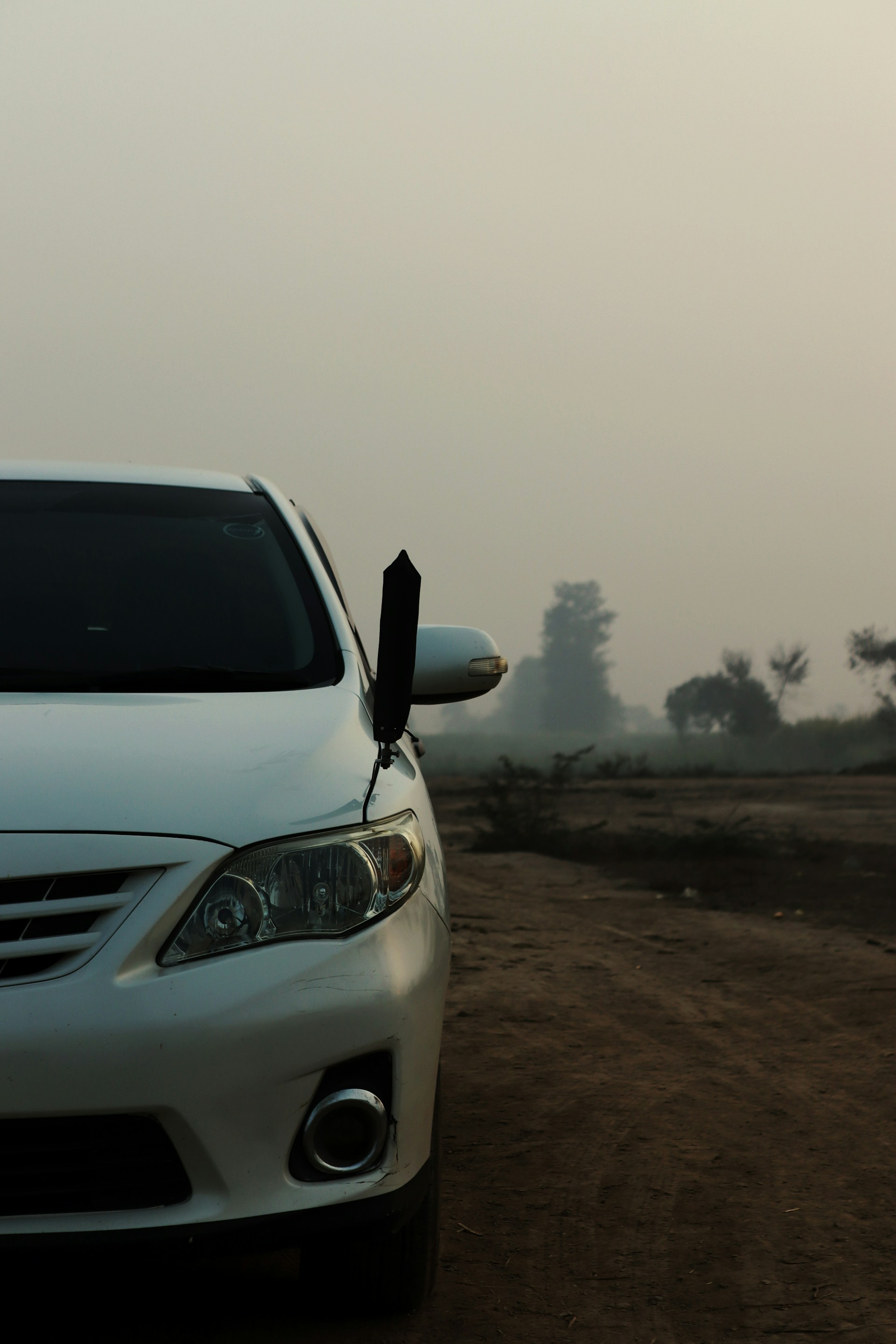 a white car parked on a dirt road