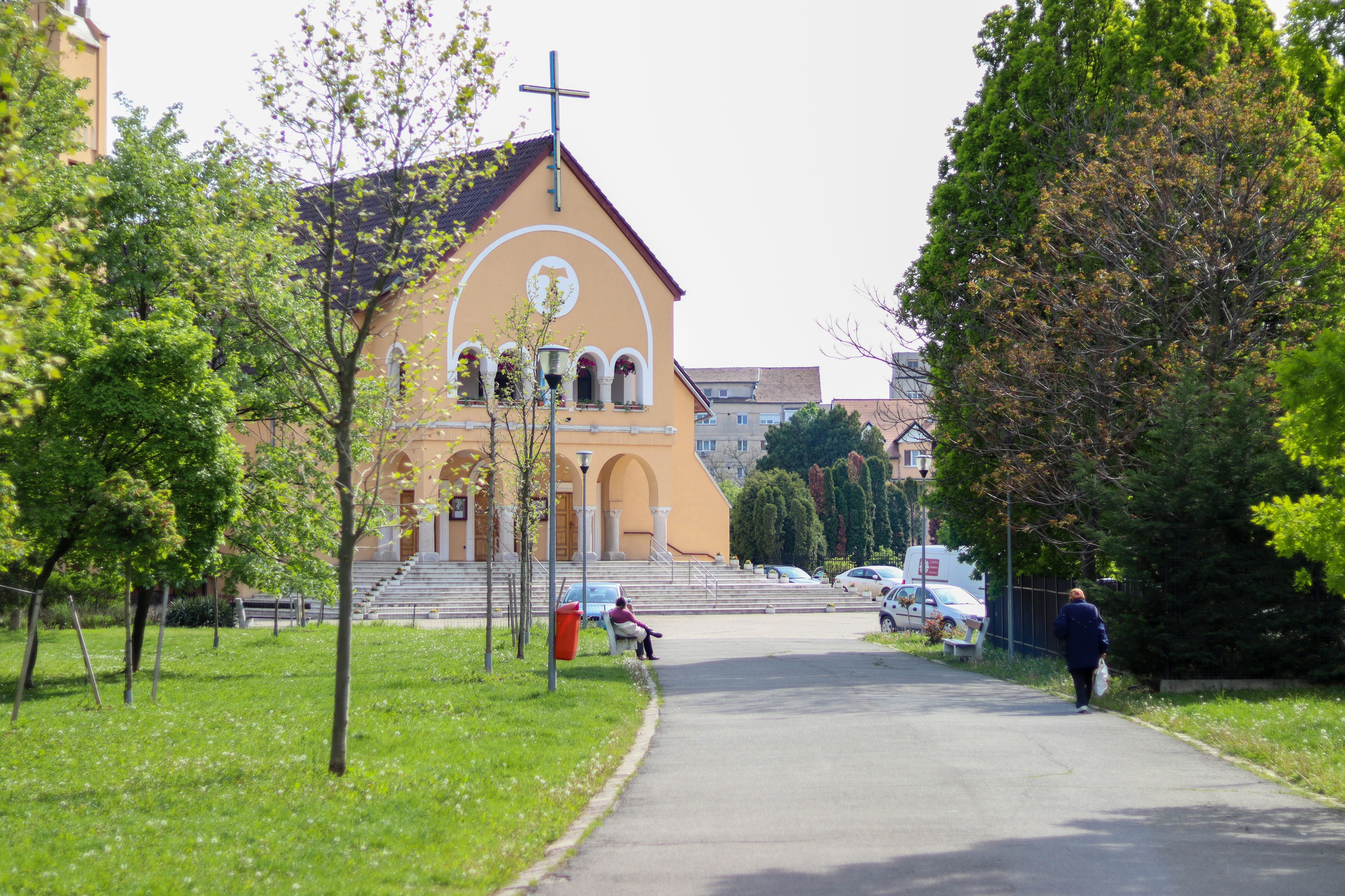 a person walking down a path in front of a church