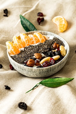 a bowl filled with fruit and nuts on top of a table