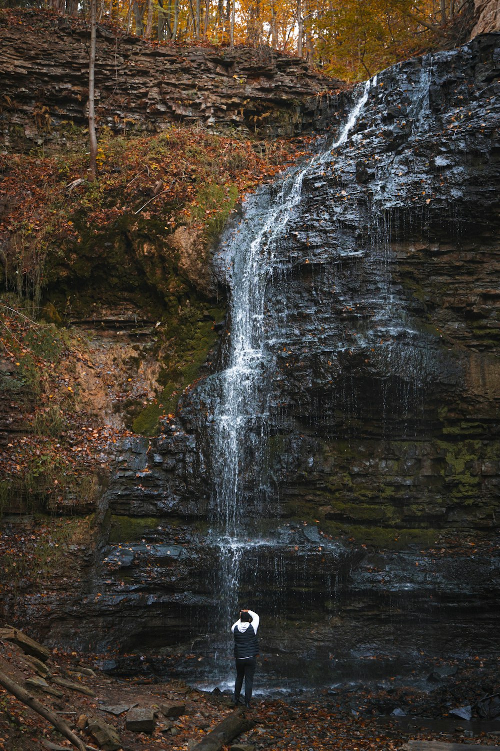 a person standing in front of a waterfall