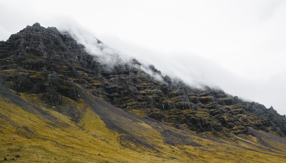 a mountain covered in fog and clouds on a cloudy day