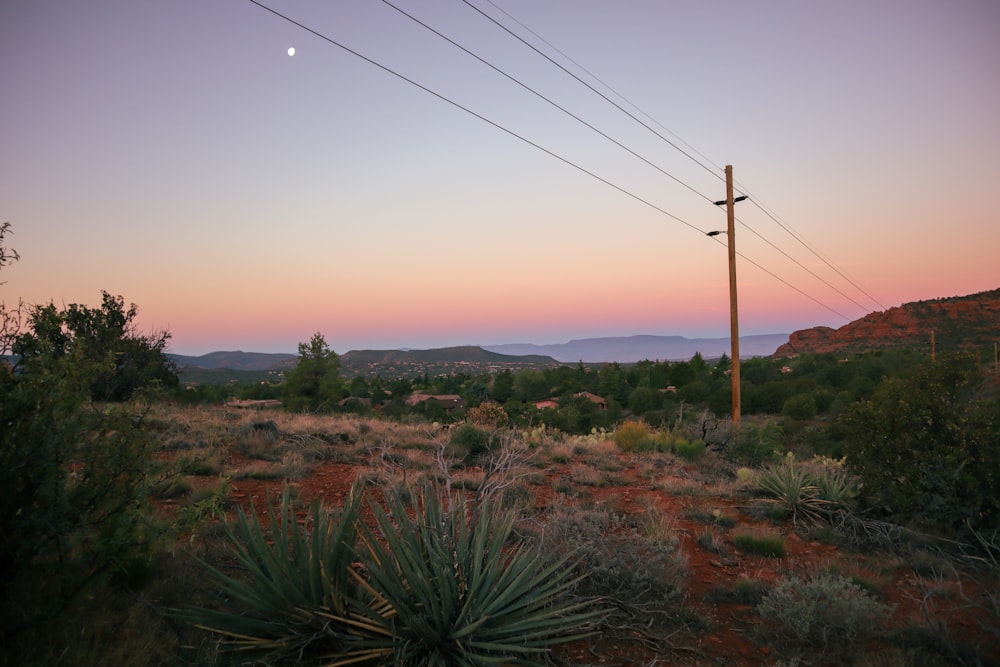 the sun is setting over a desert landscape