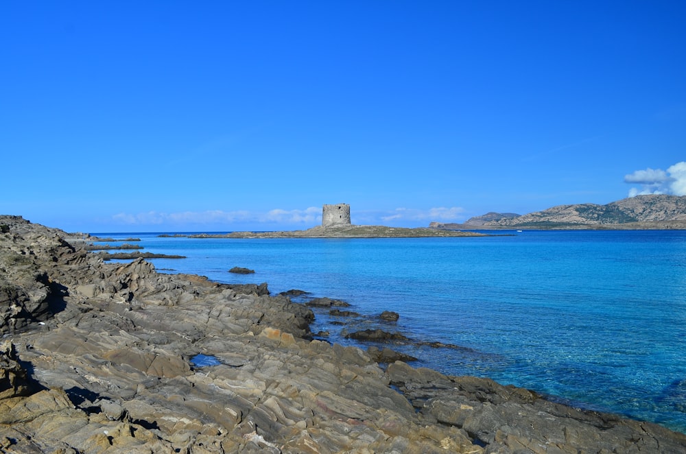 a large body of water sitting next to a rocky shore