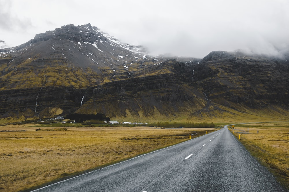 an empty road with a mountain in the background