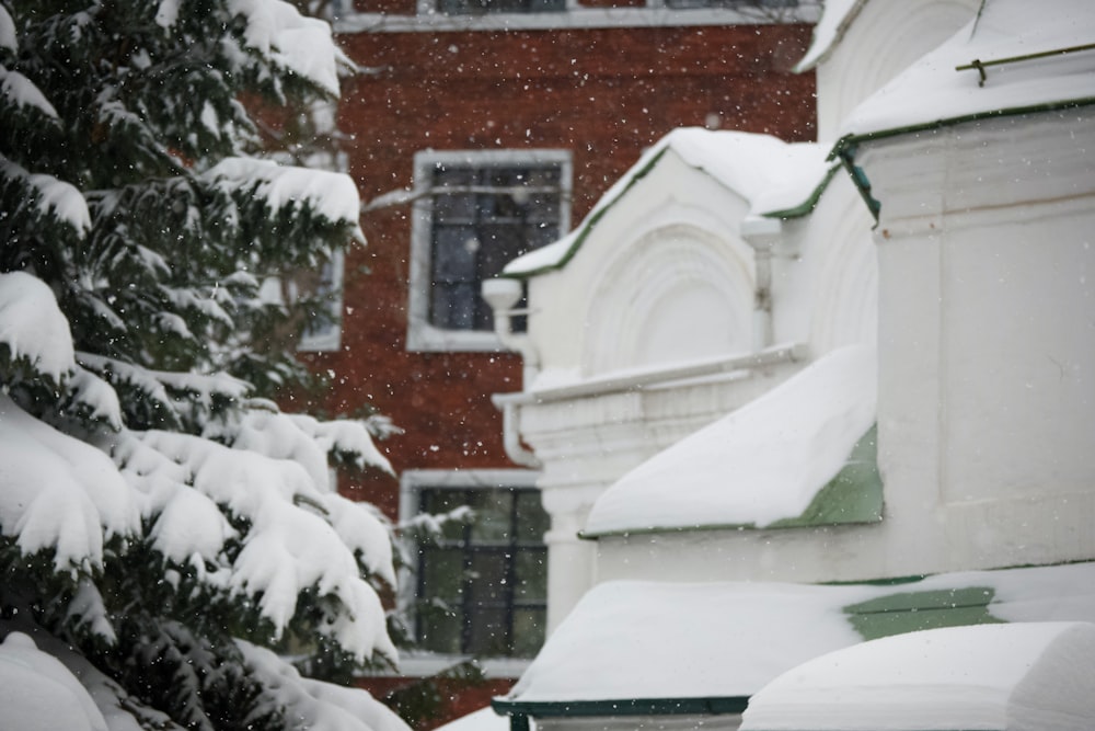 a red fire hydrant covered in snow in front of a red brick building