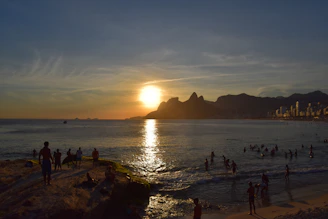 Sunset over Santa Catarina's coastline with people enjoying the beach atmosphere.