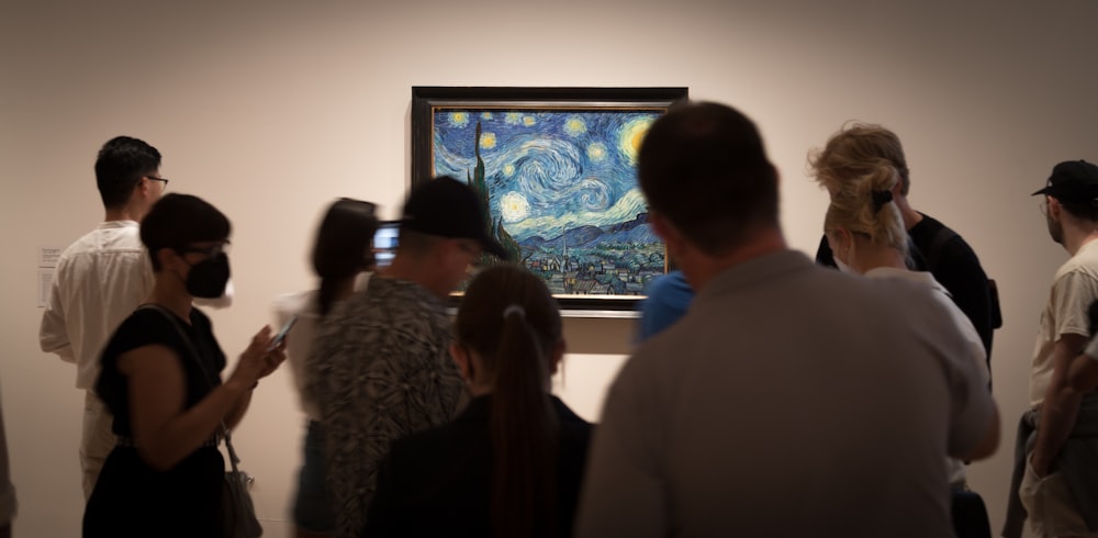 a group of people looking at a painting
