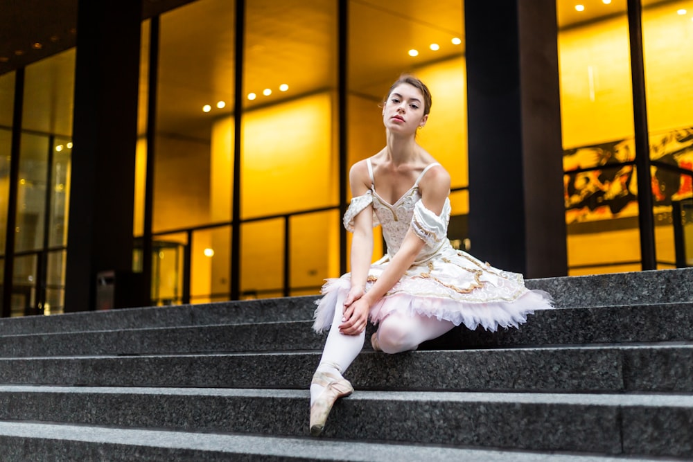 a ballerina sitting on the steps of a building