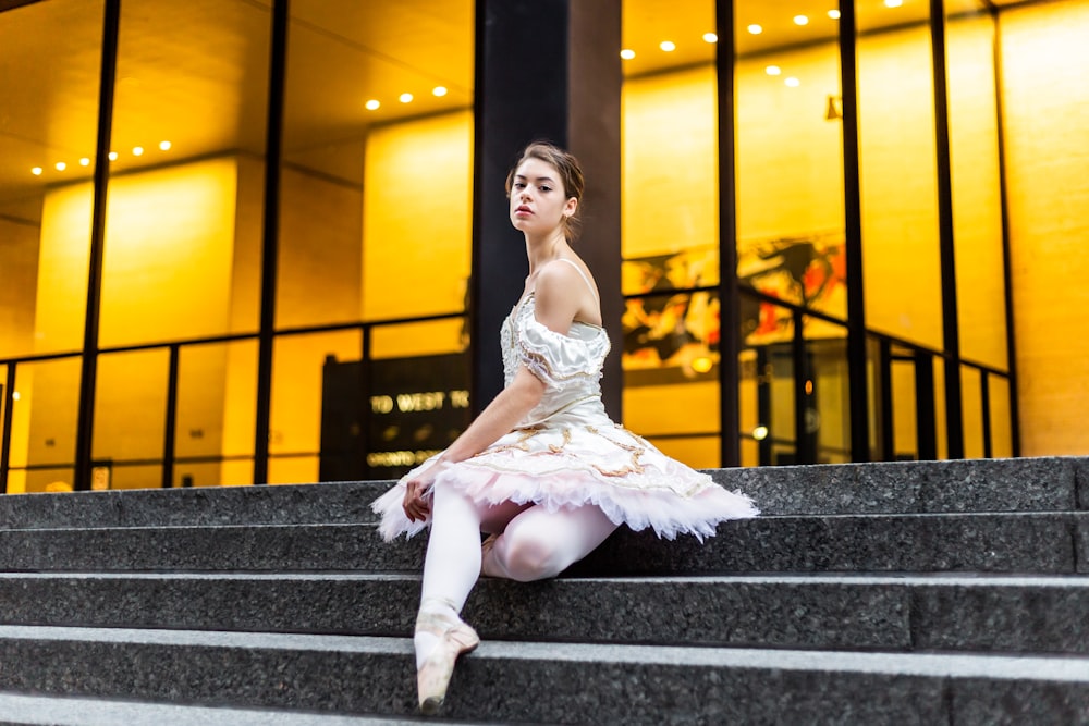 a ballerina sitting on the steps of a building