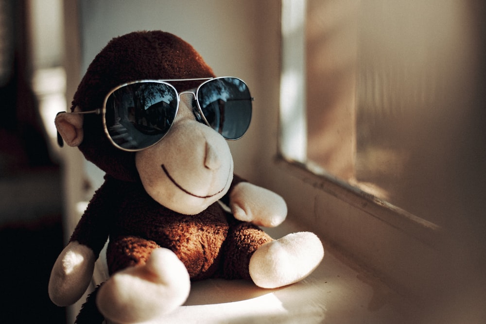 Una scimmia di peluche che indossa occhiali da sole seduta sul davanzale di  una finestra foto – Interno Immagine gratuita su Unsplash
