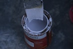 a paint can with a brush inside of it