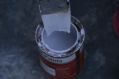 a paint can with a brush inside of it