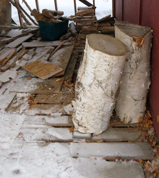 a pile of wood sitting next to a red building