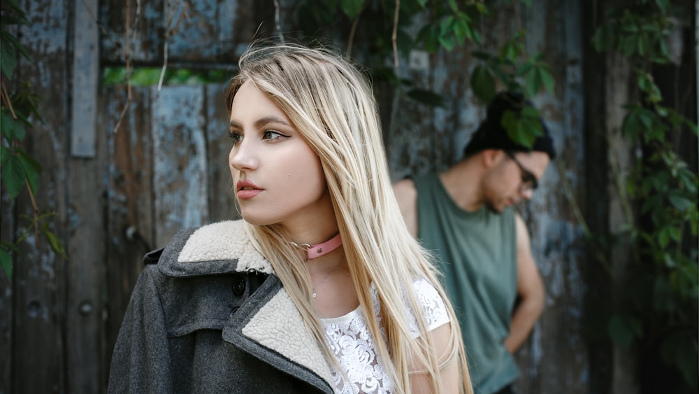 a woman with long blonde hair standing next to a man