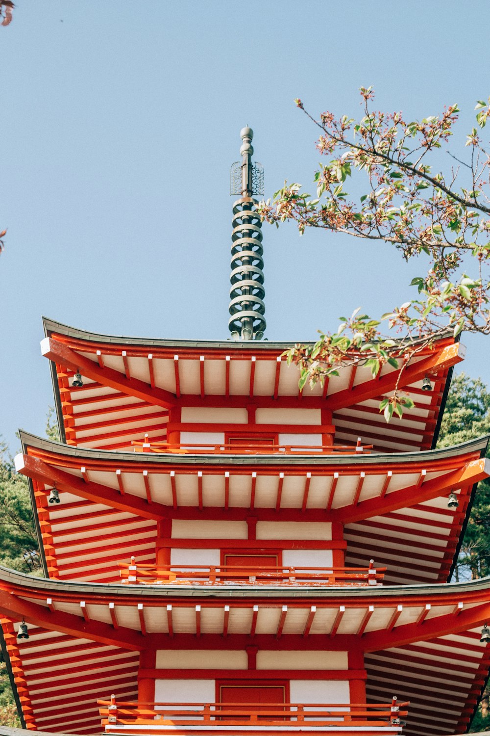 青空の下にそびえる赤と白の高層ビル