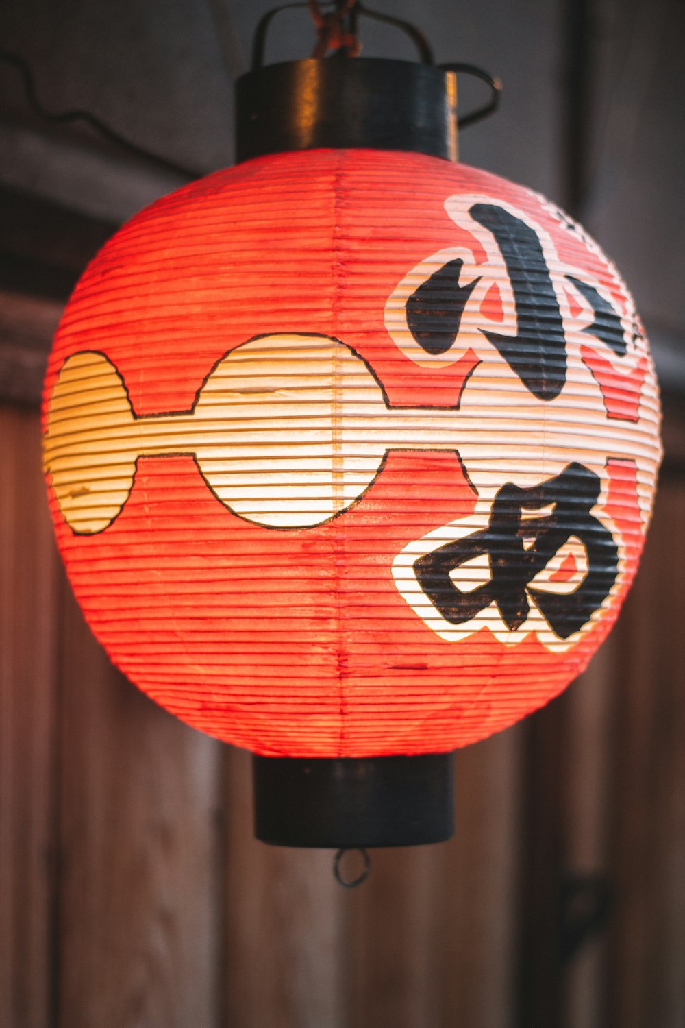 a red lantern hanging from a wooden ceiling