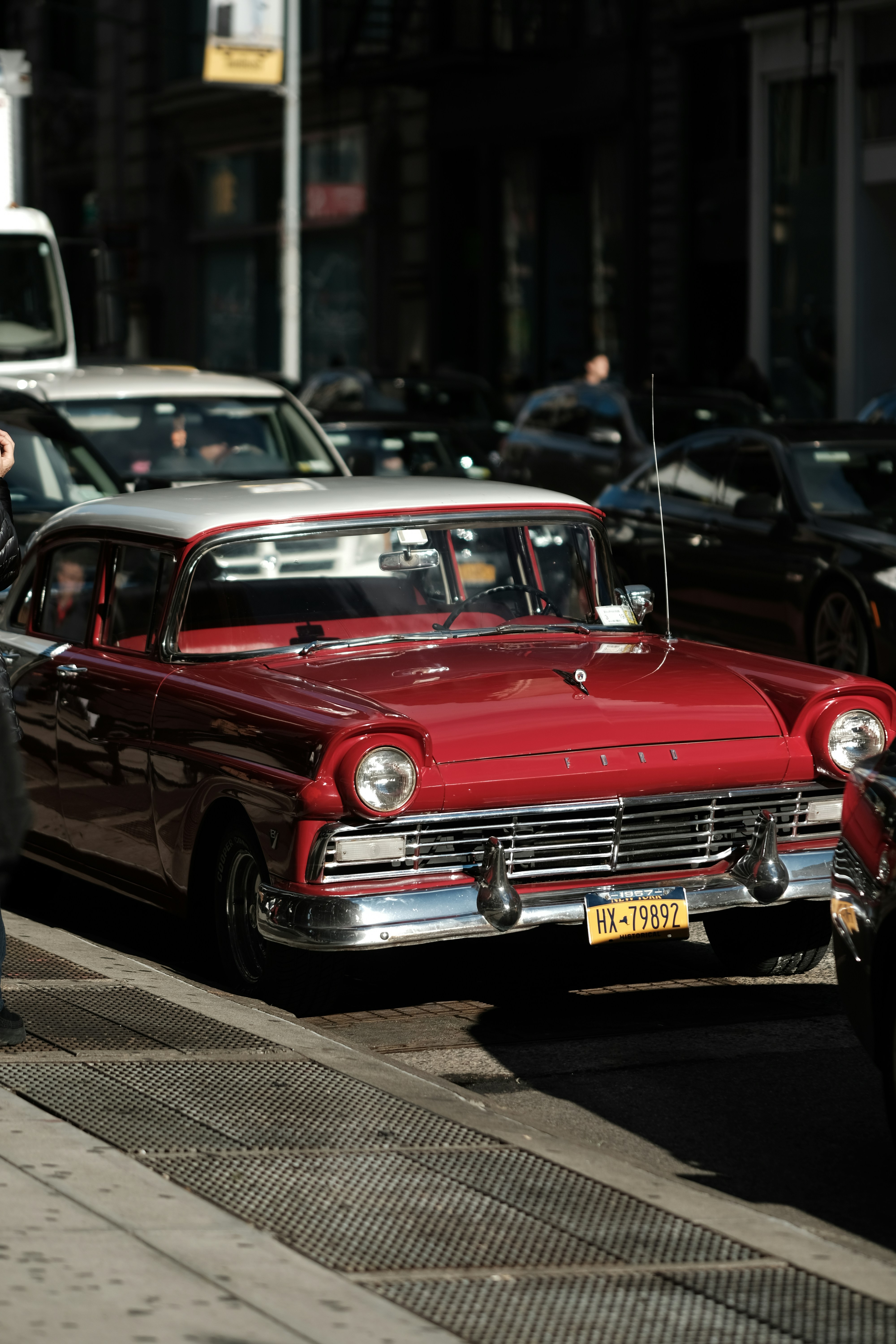 a red car is parked on the side of the road