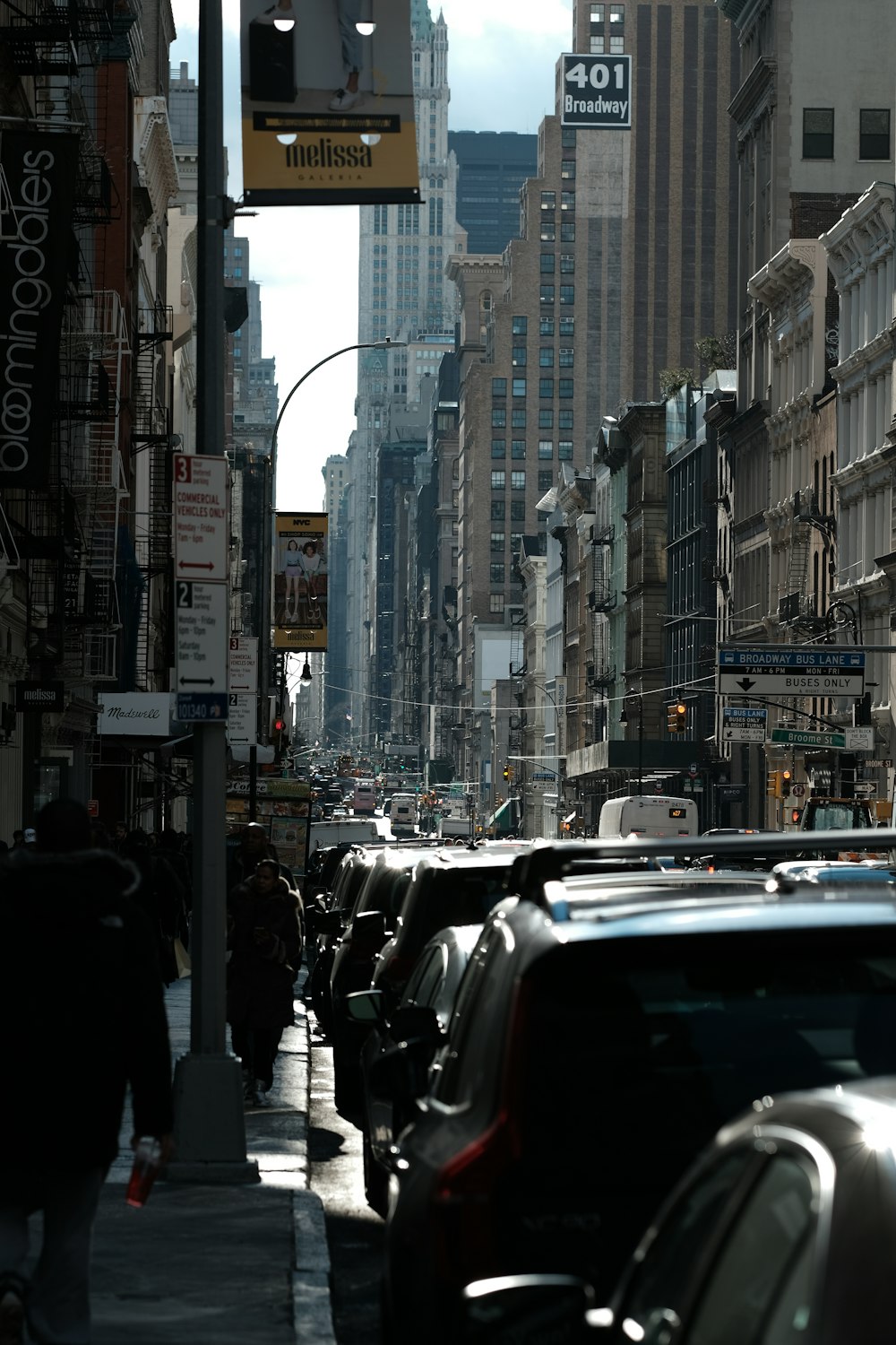 a city street filled with lots of traffic next to tall buildings