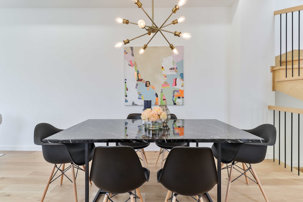 a dining room with a marble table and black chairs