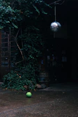 Urban football scene with a single player focused on ball work under moody lighting.