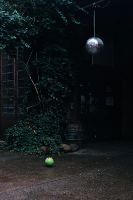 Urban football scene with a single player focused on ball work under moody lighting.