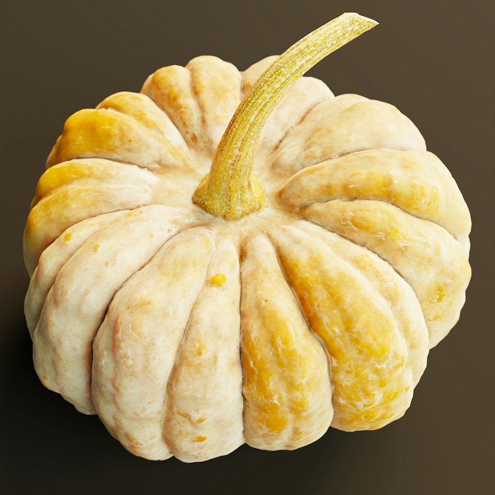 a yellow and white pumpkin on a brown background