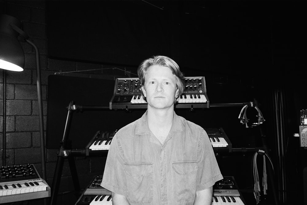 a man standing in front of a keyboard in a recording studio