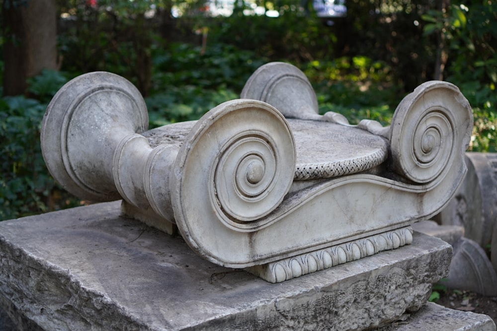 a close up of a stone object with a tree in the background