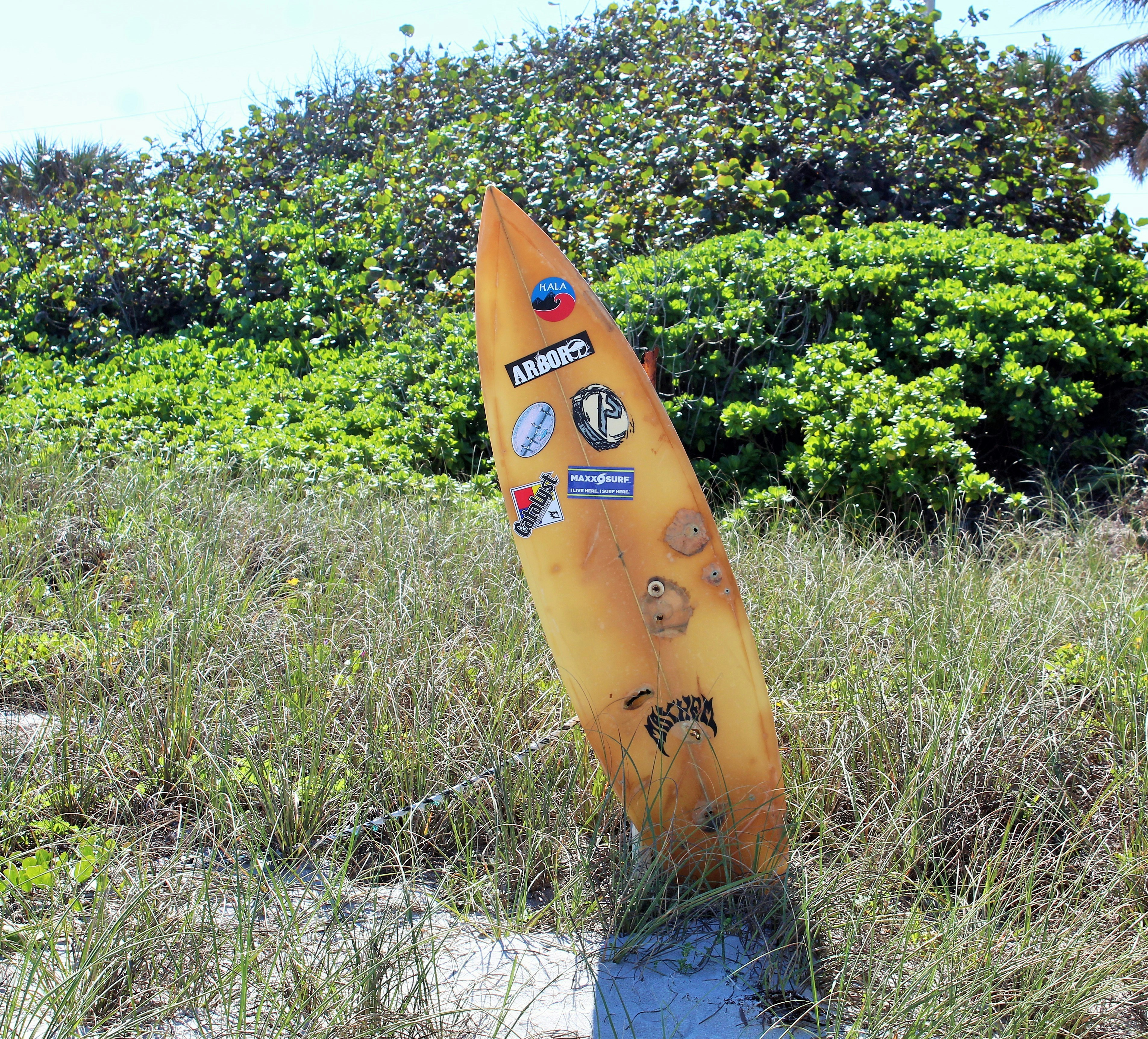 a surfboard sticking out of the sand in a field