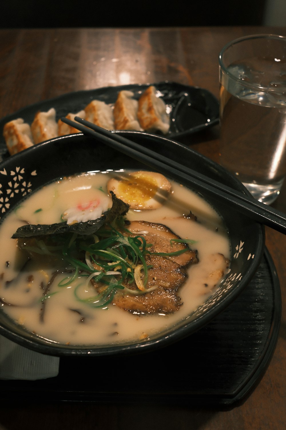 a bowl of soup on a table with chopsticks