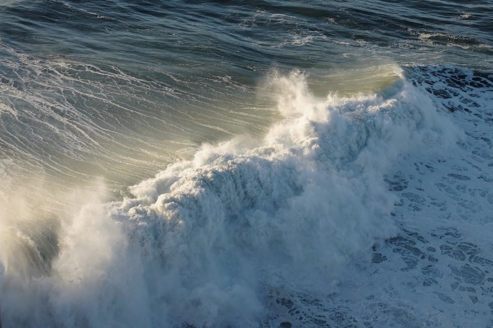 a large body of water with a wave coming towards the shore