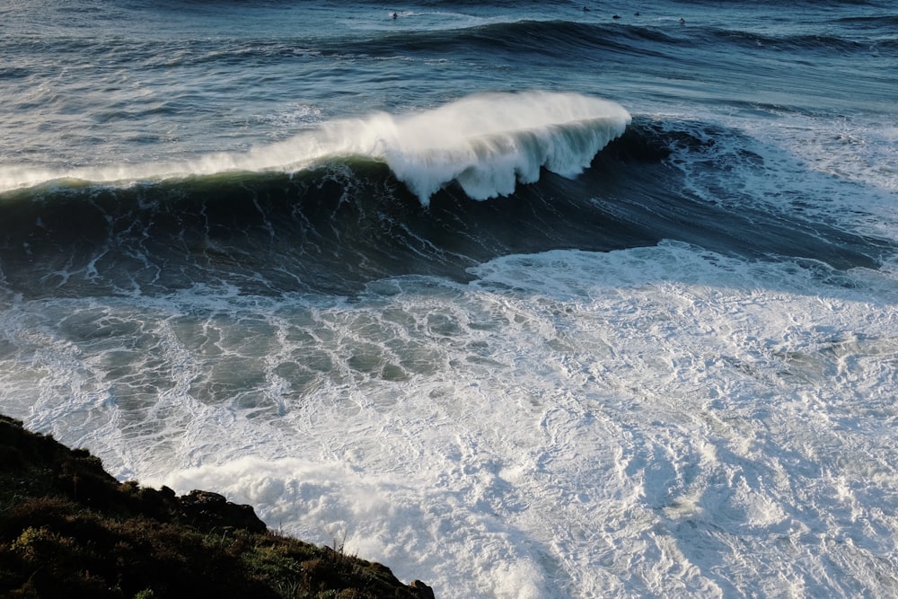 a large wave crashing into the shore of the ocean