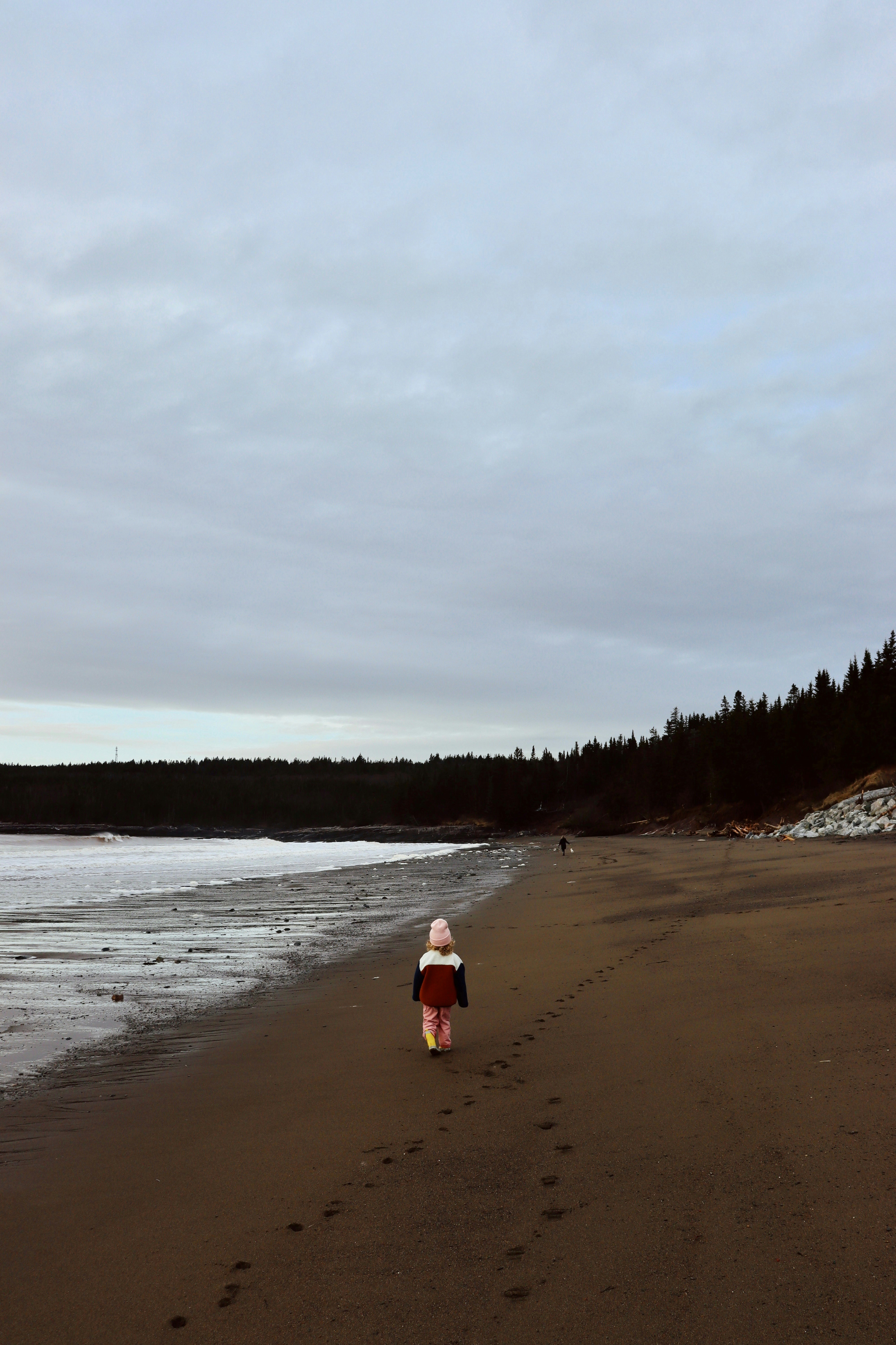 Eine Person, die an einem Strand am Meer spazieren geht