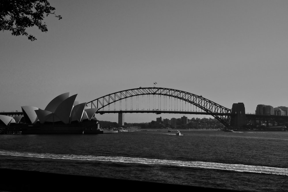 a black and white photo of a bridge over water