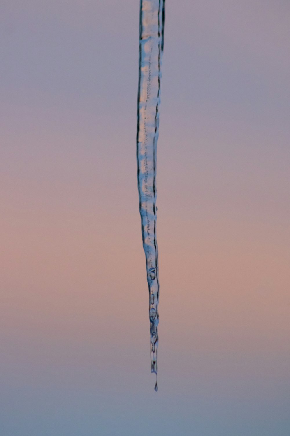 a long icicle hanging from the side of a building