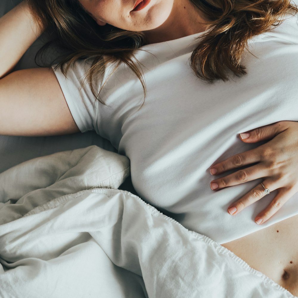 a woman laying in bed with her stomach exposed