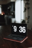 a laptop computer sitting on top of a wooden table