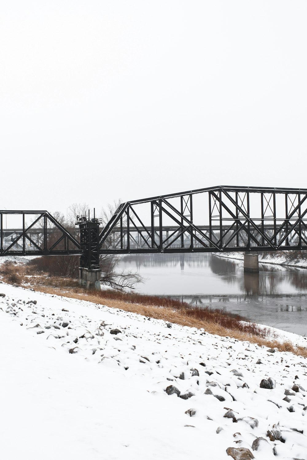 a train bridge over a frozen river in winter