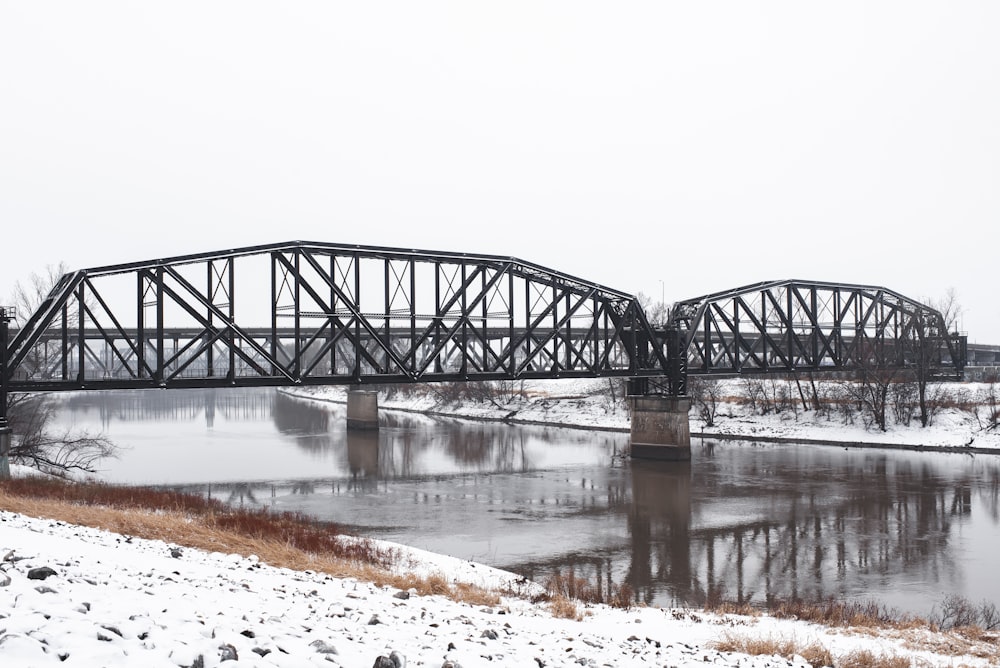 a train bridge over a frozen river in winter