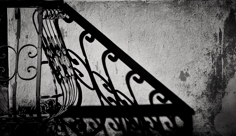 a black and white photo of a wrought iron railing
