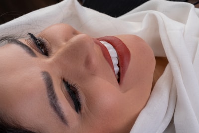Close-up of a woman smiling, showcasing vibrant lipstick from a recent beauty campaign