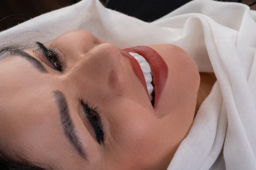 Close-up of a woman’s smile, lips slightly parted, radiating allure.
