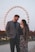 a man and a woman standing in front of a ferris wheel