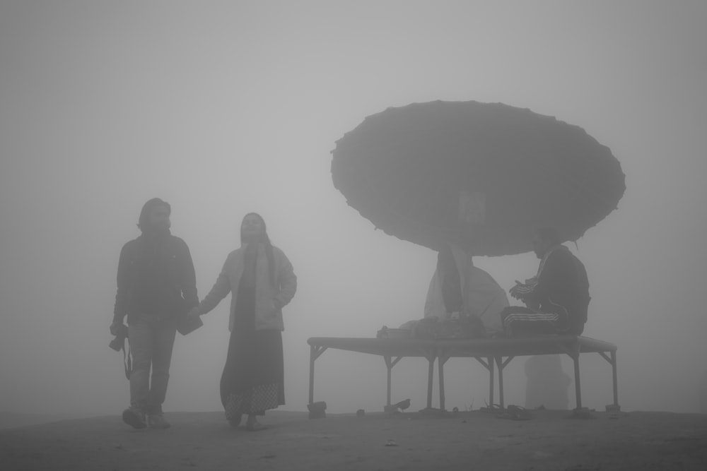 a couple of people that are standing in the fog