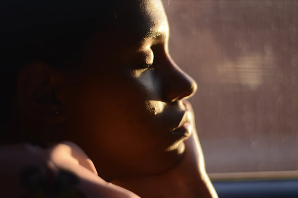 A serene moment of reflection by a volunteer helping an elderly community member, bathed in soft natural light.