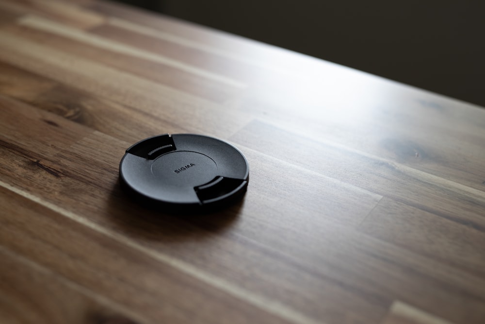 a close up of a remote control on a wooden table