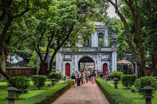 a group of people walking through a lush green park