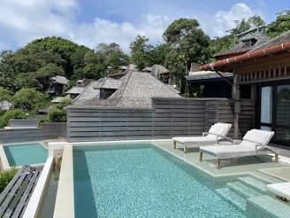 A serene poolside scene with lounge chairs and a clear blue sky.