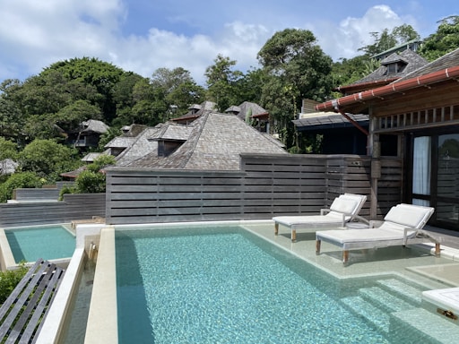 A serene poolside scene with lounge chairs and a clear blue sky.